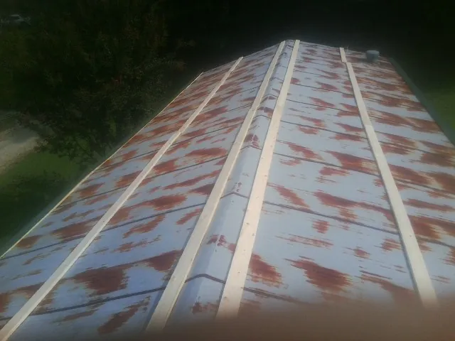 Rusted metal roof panels with new wood purlins before replacement — Storm Damage Roof Repair in Lando by Roofing Brothers