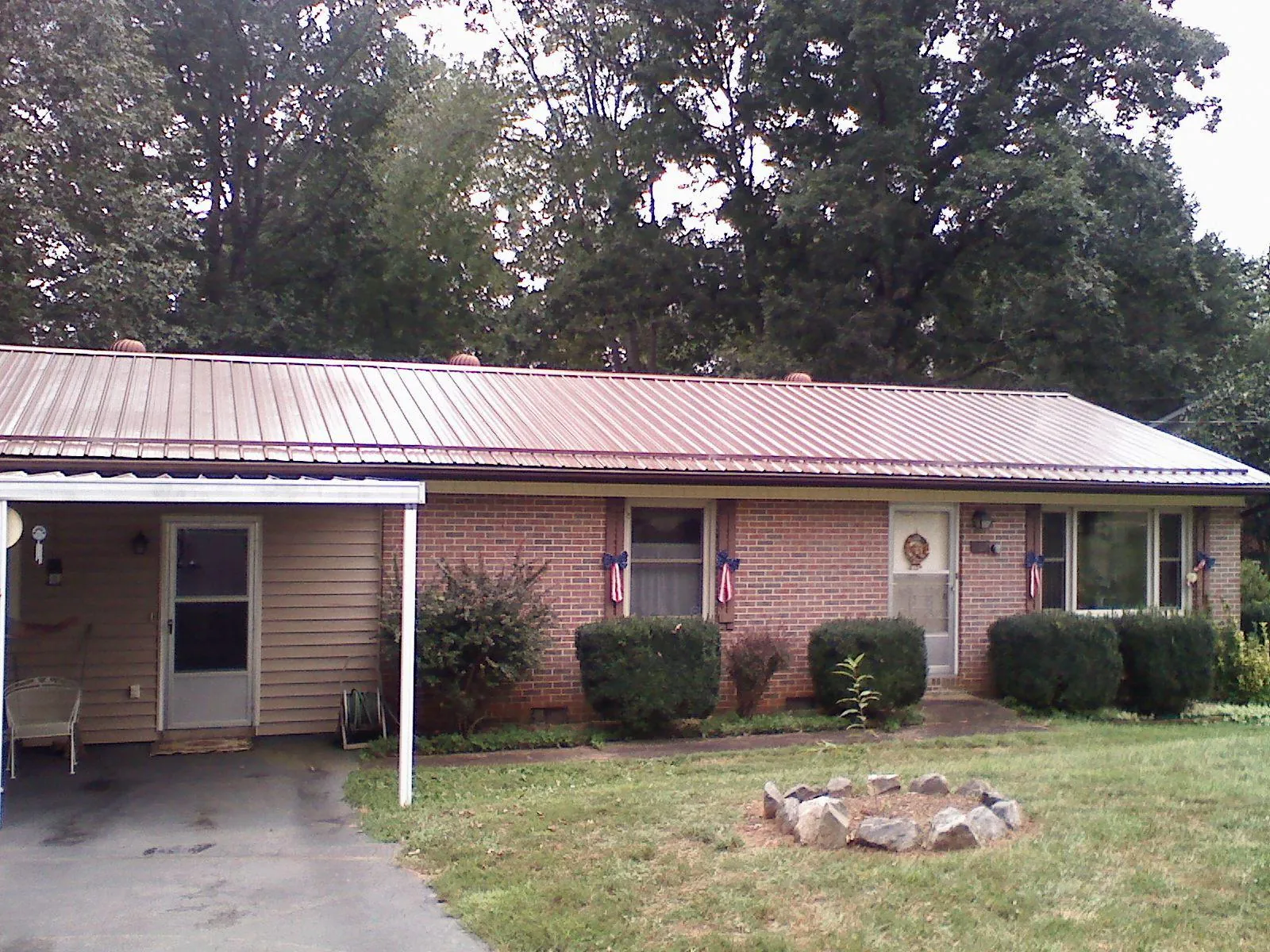 Bronze metal roof and carport on a brick ranch home — Roof Repair work by our crew in Lando